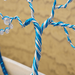 swirl of blue and silver color wire are wrapped around each other to form the treee trunk the tree trunk splits of into 2 directions 